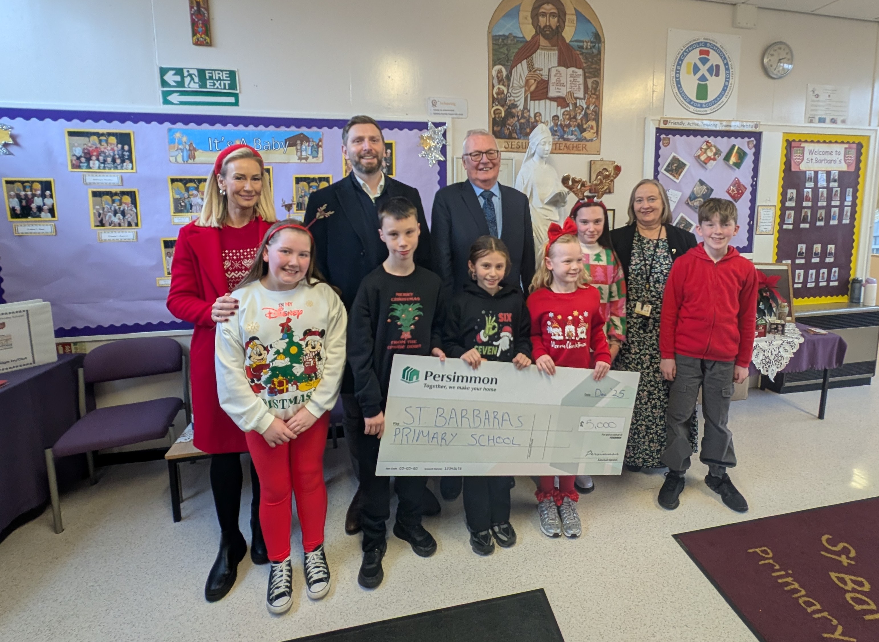 Craig Moore And Claire Eadie Presenting St Barbaras Primary School A Cheque Alongside North Lanarkshire Council Leader, Cllr Jim