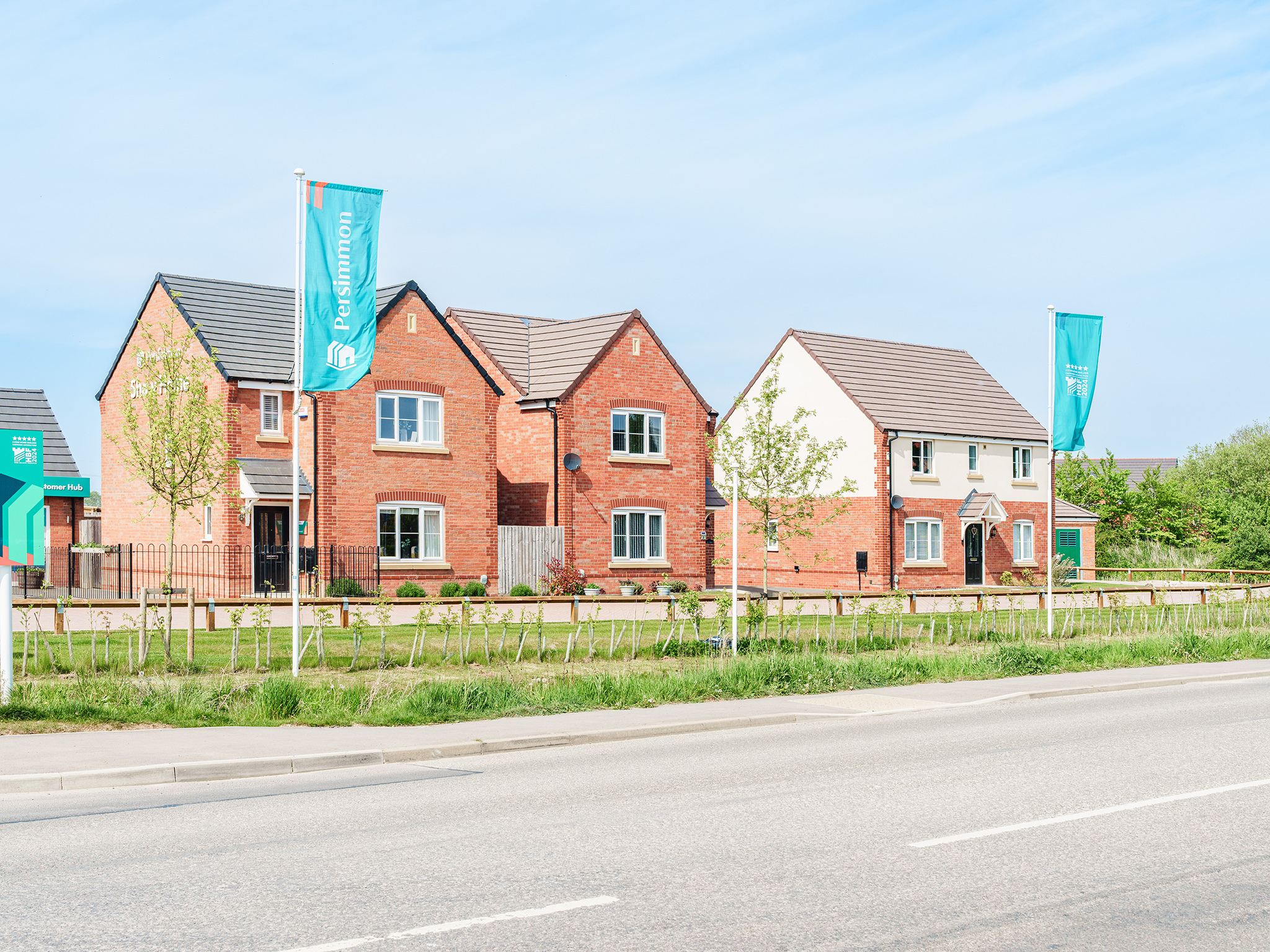 Modern red-brick Persimmon Homes at The Maples development in Spalding, Lincolnshire with roadside view.