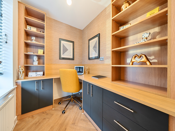 Modern home office with built‑in shelving, desk area and warm wood finishes.