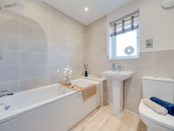 Family bathroom in The Burnham at Bluebell Meadow with bath, basin and WC.