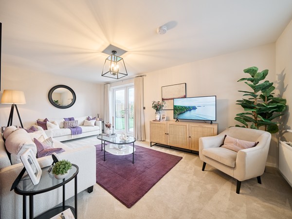 Modern-living-room-with-neutral-furnishings-purple-accent-rug-glass-coffee-table-and-patio-doors-leading-outside