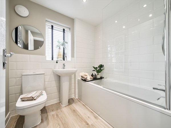 Contemporary-family-bathroom-with-white-wall-tiles-bath-with-shower-screen-pedestal-sink-and-window.