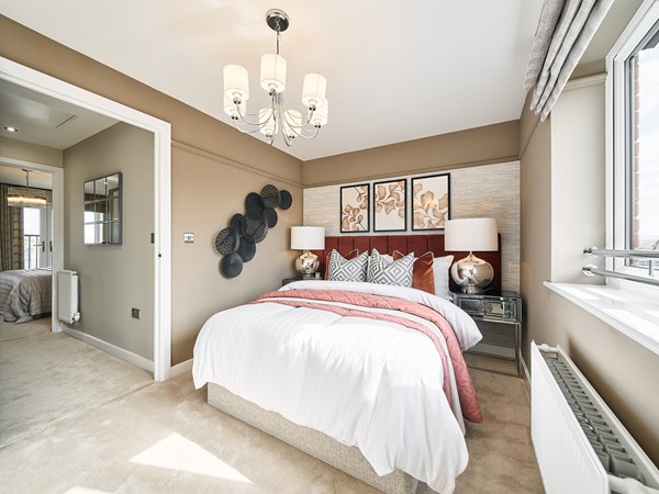 Elegant-bedroom-with-upholstered-headboard-feature-wall-bedside-lamps-and-soft-neutral-decor.