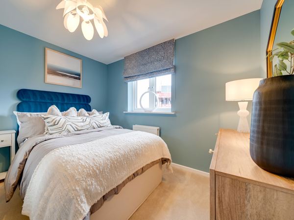 Main bedroom in the Kielder show home at Hawthorn Park with patterned feature wall and neutral décor.