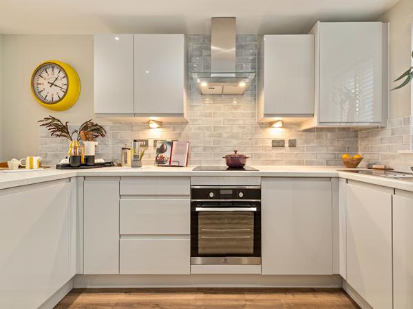 Compact modern kitchen with integrated appliances and light grey cabinets.