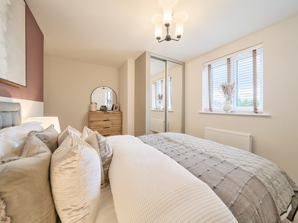Bedroom-with-mirrored-wardrobes-neutral-decor-double-bed-and-large-window-with-natural-lighting
