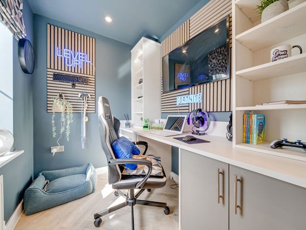 Study in The Burnham at Bluebell Meadow with fitted desk, shelving and gaming setup.