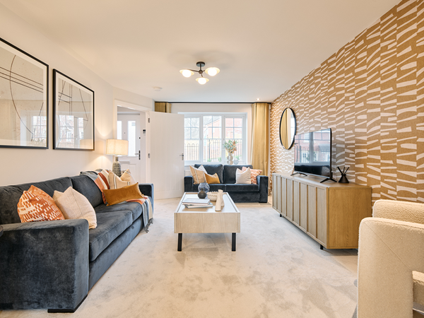 Modern living room with patterned feature wall, dark sofas, and light wood furniture.