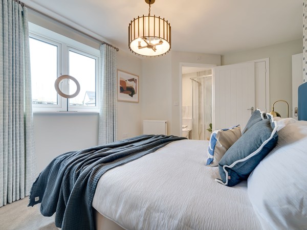 Elegant bedroom with a double bed, statement headboard, en suite shower room and large window.