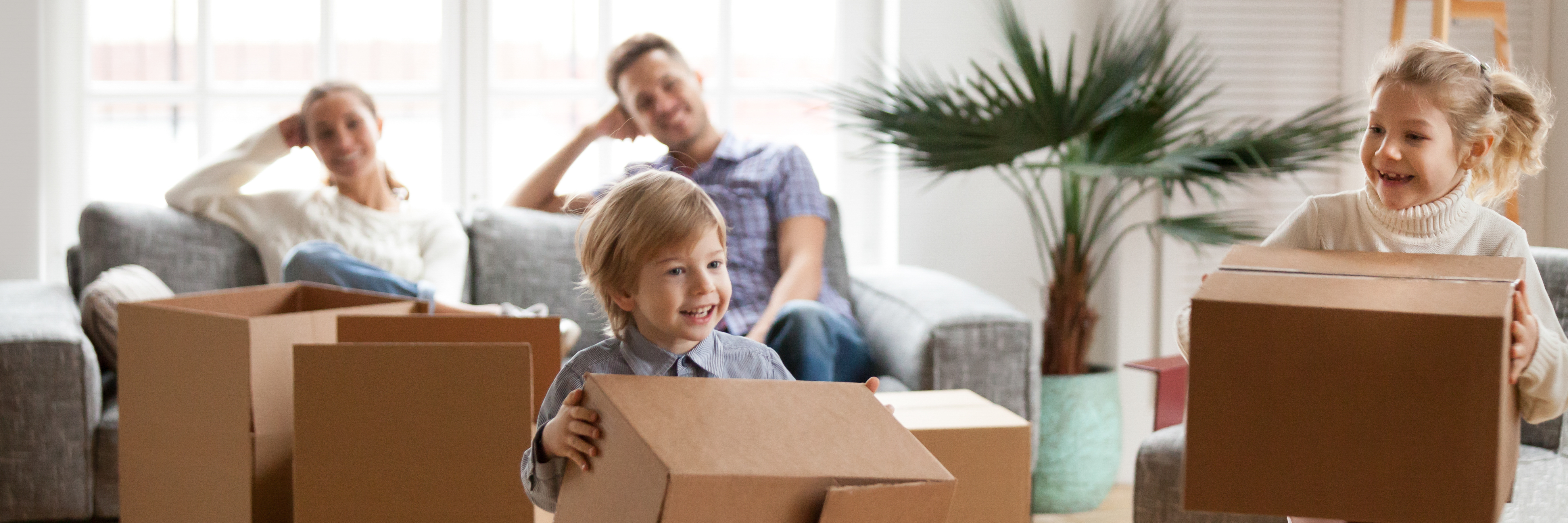 Couple on Couch, Children Play with Boxes