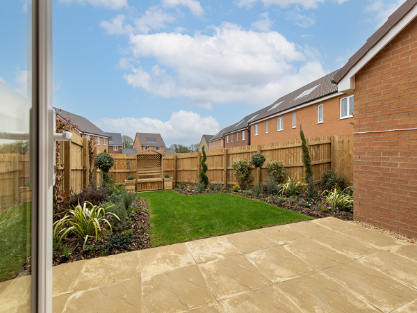 Rear garden with patio, lawn and surrounding fenced borders.