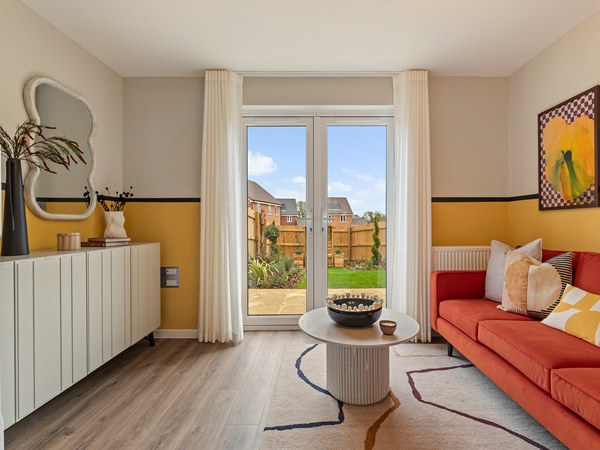 Living room facing garden with sideboard, coffee table and bright sofa.