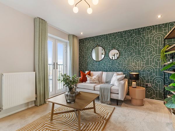 A bright and colourful modern living room with a geometric wallpapered wall and a cream sofa. 