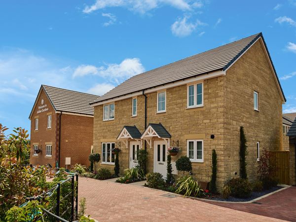 The exterior of a modern Persimmon home against a bright blue sky.