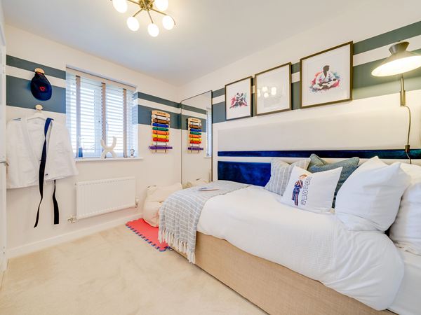 Child’s bedroom in The Burnham at Bluebell Meadow with single bed and soft furnishings.
