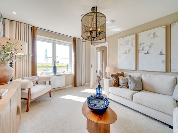 Living room in The Burnham at Bluebell Meadow with large window and soft neutral styling.