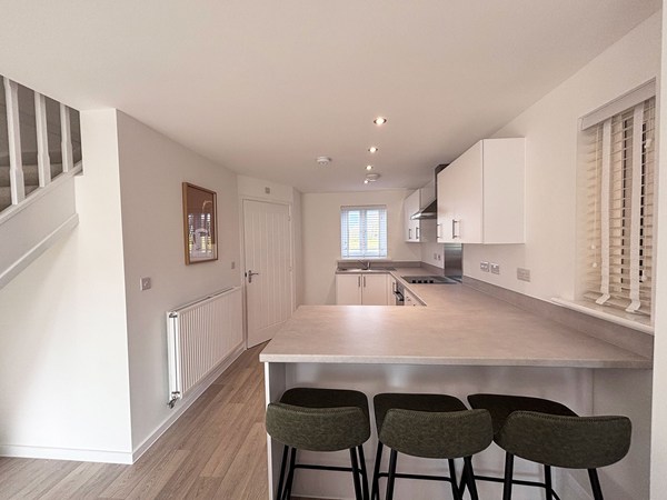 Modern kitchen with breakfast bar in new-build home at Trevithick Manor Park.
