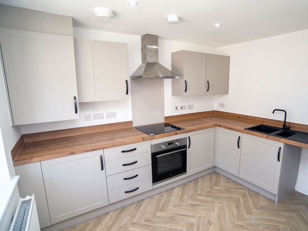 Modern kitchen with wood-effect worktops in The Whinfell at Trehenlis Gardens.