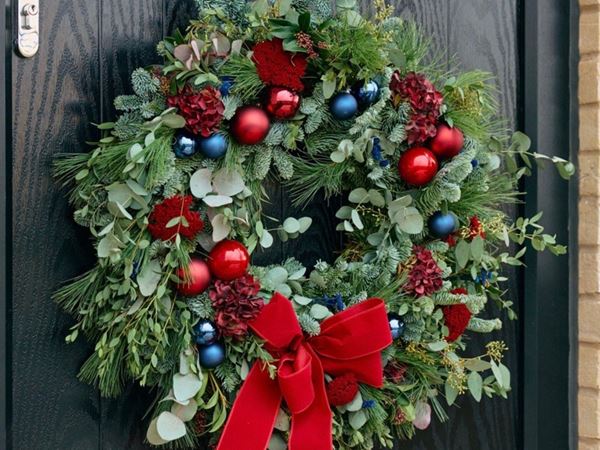 A Christmas wreath on a modern door of a Persimmon home.