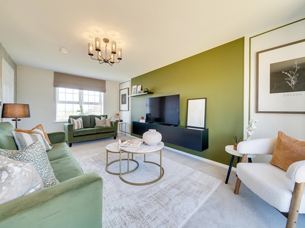 Green coloured living room with green velvet sofas and a big TV