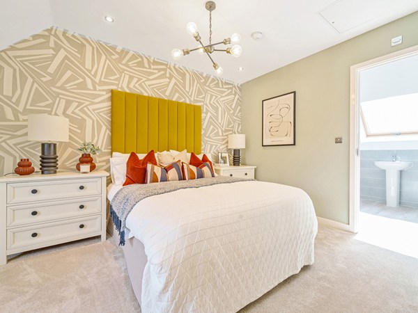 Bedroom with a feature headboard, fitted carpet, bedside tables and en suite access.