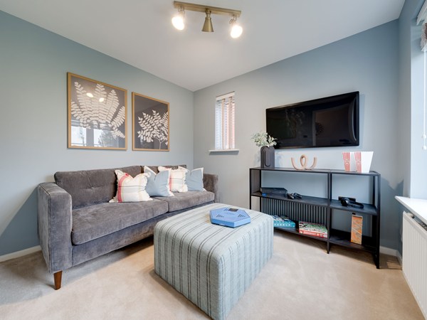 Kielder living room with grey sofa, television and footstool