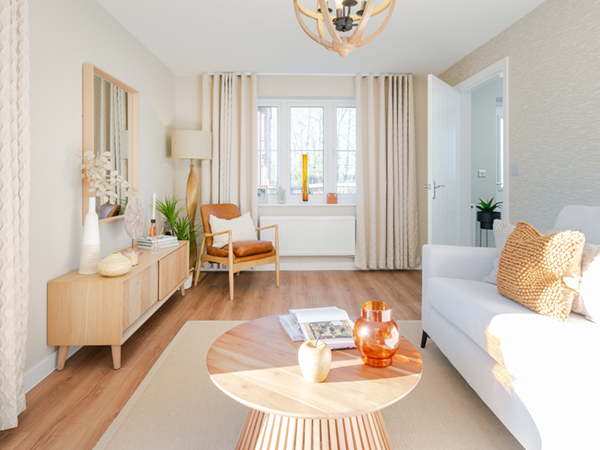 Bright living room with cream sofa, wooden furniture and large window
