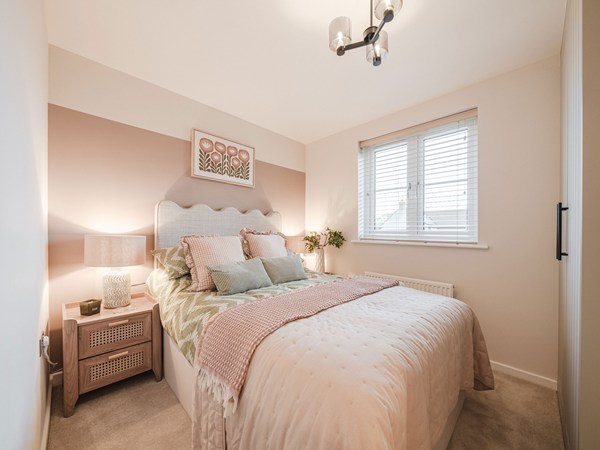 Modern bedroom with double bed, feature wall and large window.