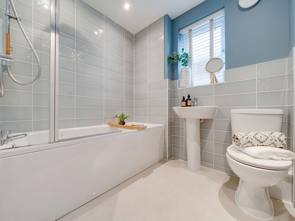 Kielder bathroom with bath, shower screen and grey tiling