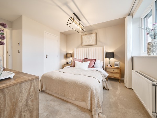 Elegant-double-bedroom-with-upholstered-headboard-neutral-decor-pink-cushions-and-large-window-natural-lighting