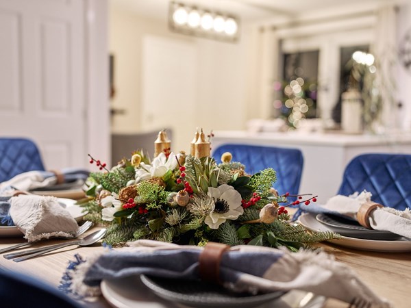 A modern open-plan kitchen and dining room, with a dining table set up for Christmas day.