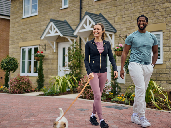 young couple walking their dog on a new build estate