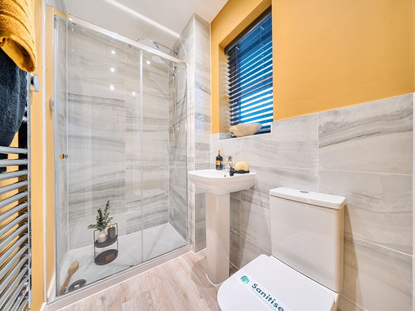 Contemporary en-suite with large glass enclosure and marble-effect tiles.