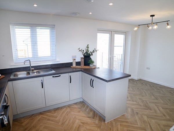 Open-plan kitchen and dining area in the Greenwood at Trehenlis Gardens.