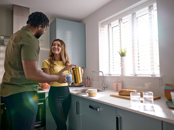 young couple making tea in a modern blue kitchen