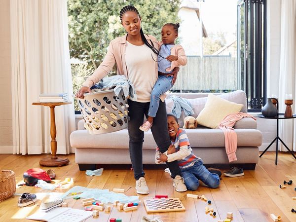 A mother and her children in a messy living room.