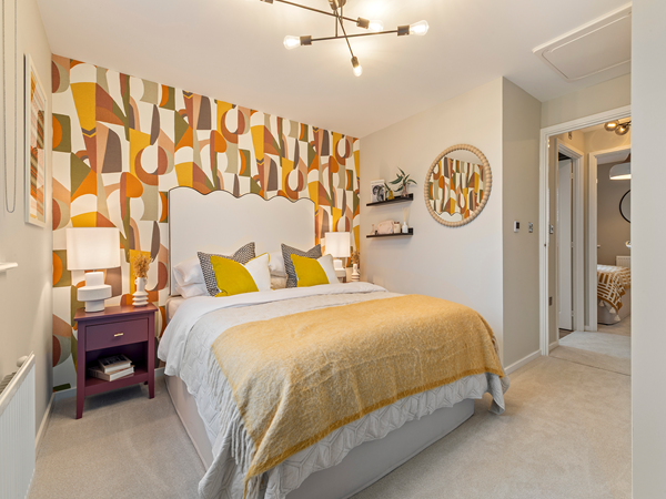 Bedroom with printed wallpaper, double bed and bedside tables.