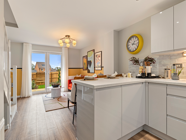 Open kitchen‑living area with bar seating and French doors leading to garden.