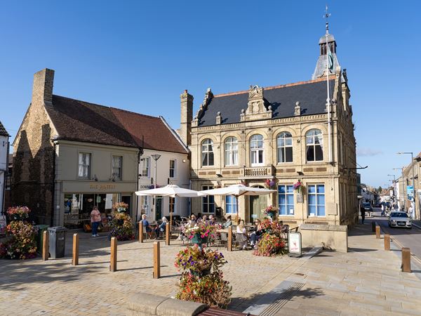 Historic Downham Market town square with café and period buildings near Persimmon Homes The Willows in Norfolk